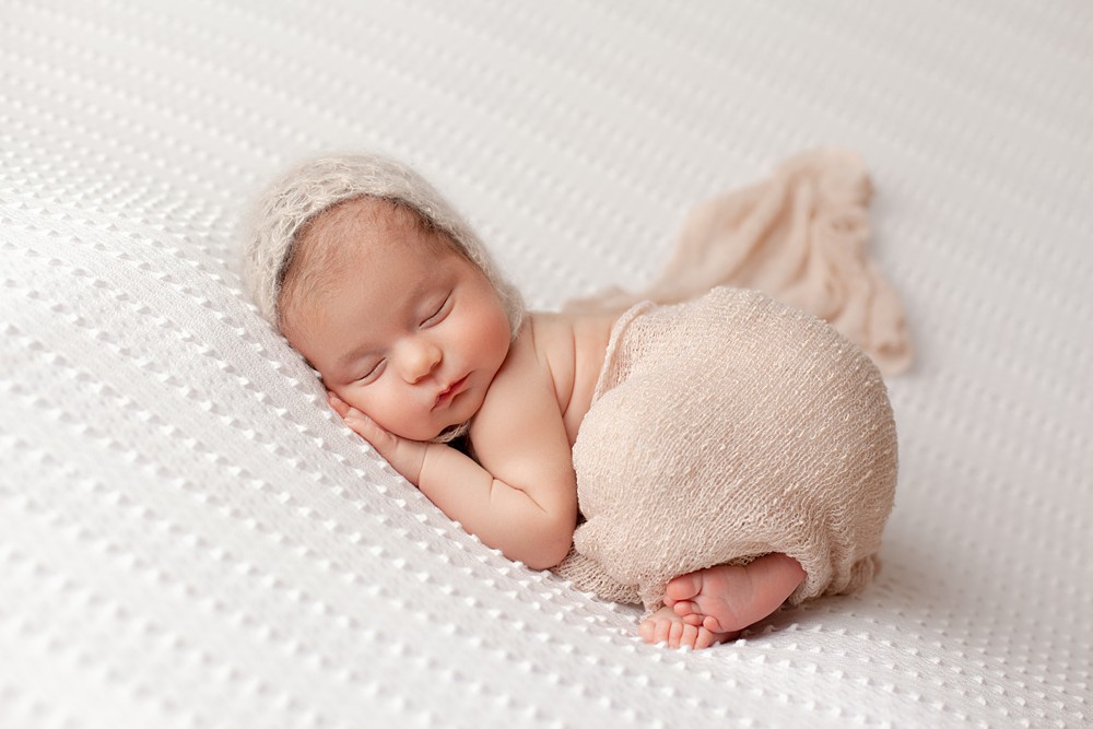 Bonnets add a girly yet vintage feel to the newborn portrait. 