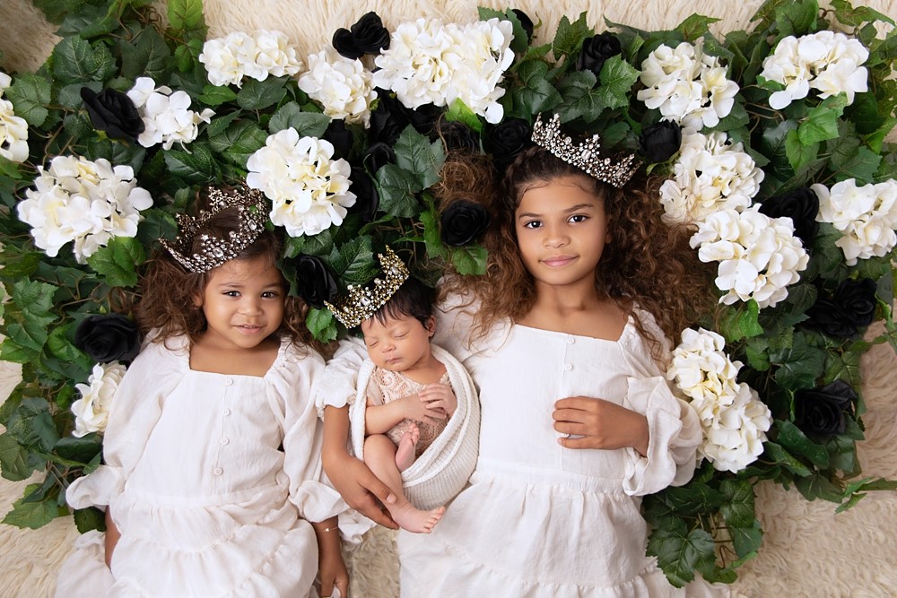 Newborn with 2 siblings laying down