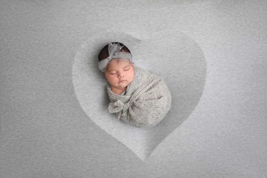 Newborn girl wrapped in Grey with a heart shape in Westminster California Studio 