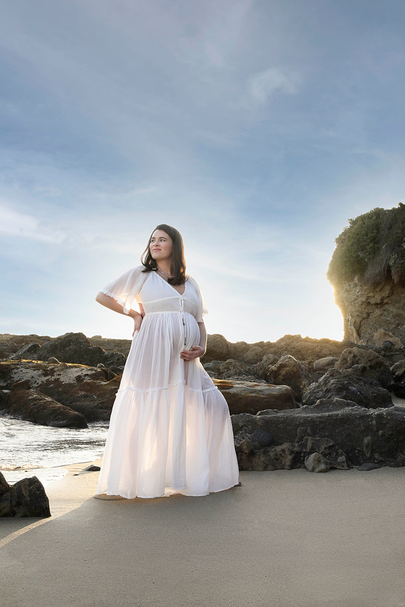 pregnant mom in white dress on the beach