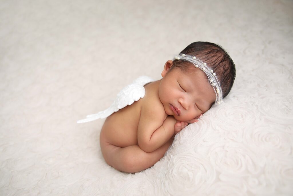 Newborn girl with headband and wings from a Garden Grove Newborn Photographer