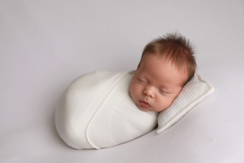 Westminster Newborn Photographer photographed this sweet newborn boy in all white.