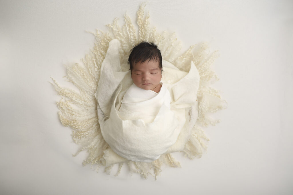 Newborn baby sleeping during a professional newborn session at a studio in Orange County, CA.